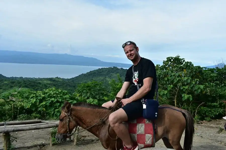 Me on horseback on a green hillside above a large lake